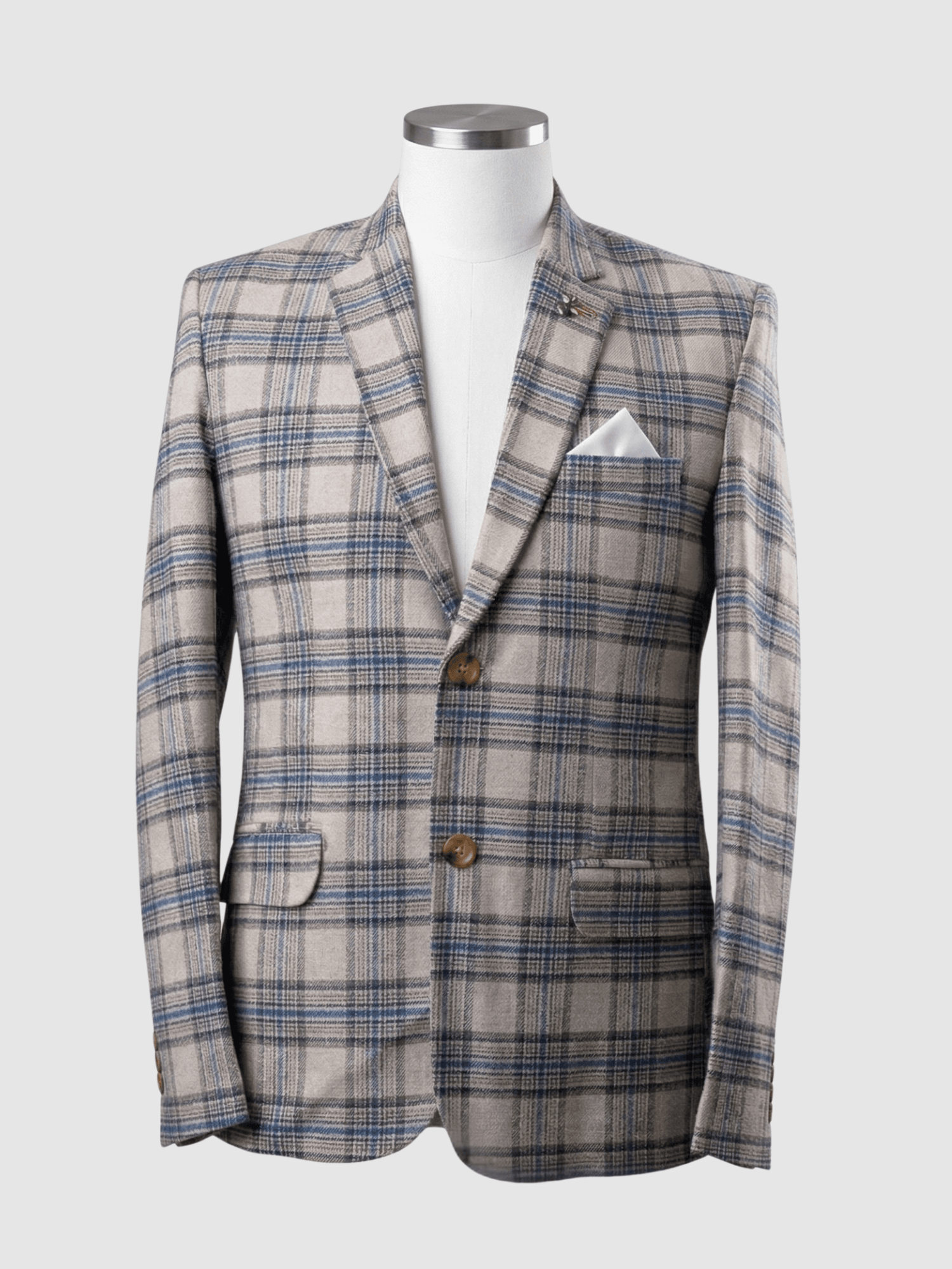 Turkish Beige and Blue Plaid Smart Fit Coat - Kamal Clan A men's tailored smart fit coat in a beige and blue plaid pattern on a mannequin. The coat features a lapel pin, light brown buttons, and a crisp white pocket square. Turkish stitching and branded fabric are present.