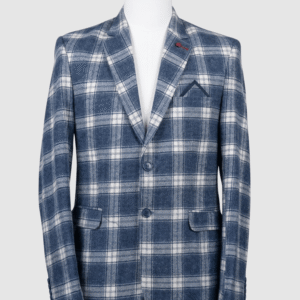 A men's tailored smart fit coat in a bold blue and white plaid pattern on a mannequin. The coat features a red lapel pin, navy buttons, and a pointed navy pocket square. Turkish stitching and branded fabric are present.