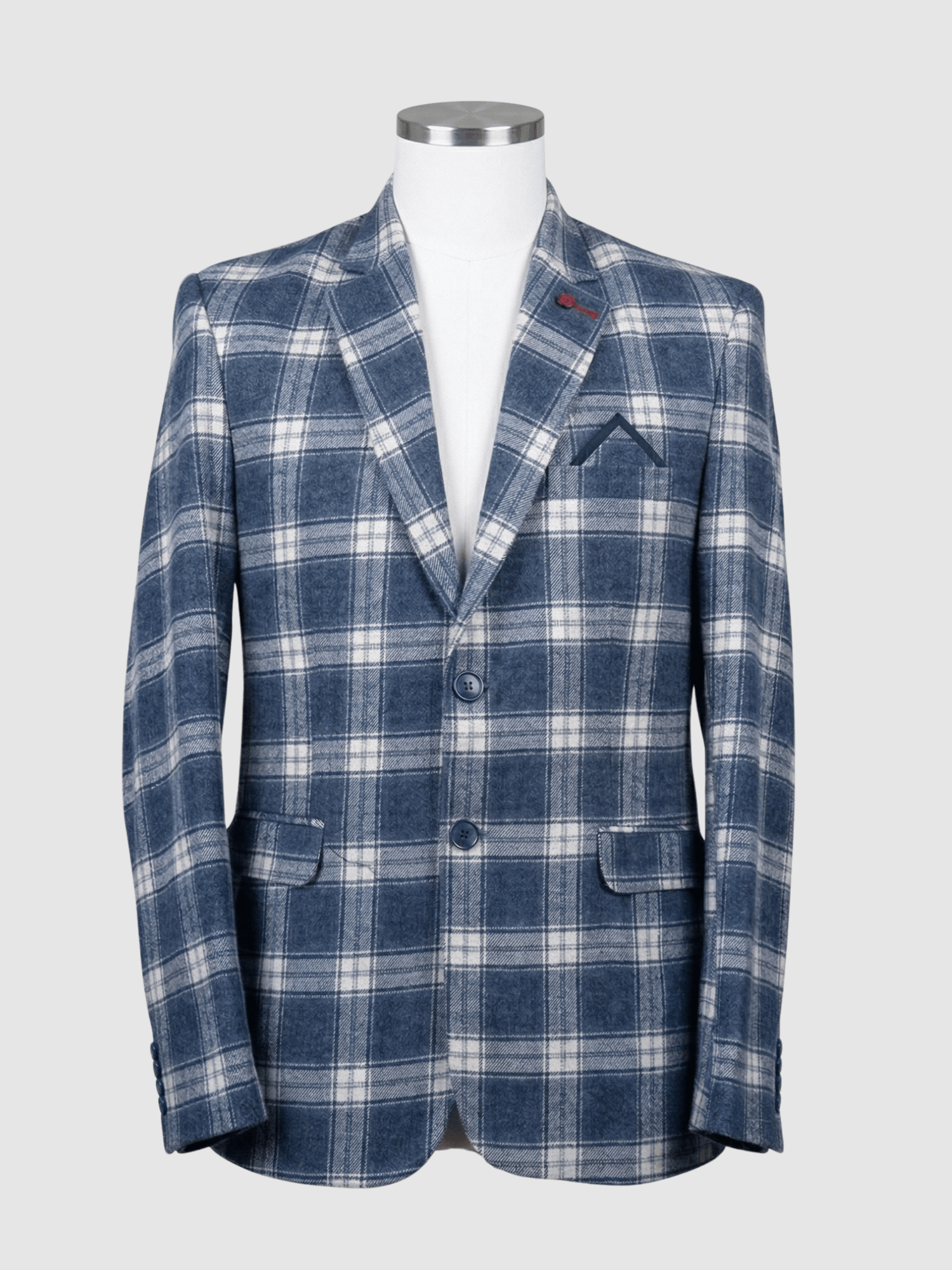 Turkish Blue and White Plaid Smart Fit Coat - Kamal Clan A men's tailored smart fit coat in a bold blue and white plaid pattern on a mannequin. The coat features a red lapel pin, navy buttons, and a pointed navy pocket square. Turkish stitching and branded fabric are present.