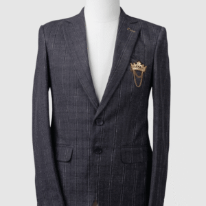 A men's tailored smart fit coat in charcoal grey with subtle pinstripes on a mannequin. The coat features a gold lapel pin, dark buttons, and a prominent gold crown brooch with chains on the breast pocket. Turkish stitching and branded fabric are present.