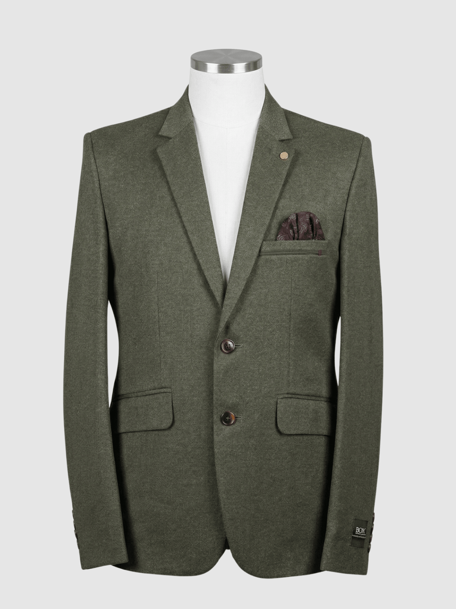 Turkish Olive Green Smart Fit Coat - Kamal Clan A men's tailored smart fit coat in a solid olive green fabric on a mannequin. The coat features a subtle lapel pin, dark buttons, and a dark patterned pocket square. Turkish stitching and branded fabric are present.