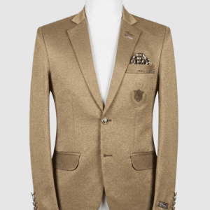 A tailored smart fit coat made of textured camel Iranian fabric on a mannequin. The coat features an embroidered chest crest, a metallic lapel pin, and a black and white checkered pocket square.
