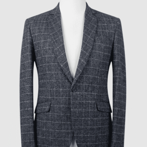 A tailored smart fit coat made of charcoal grey grid patterned Iranian fabric on a mannequin. The coat features a clean, minimalist design with dark buttons and no pocket square.